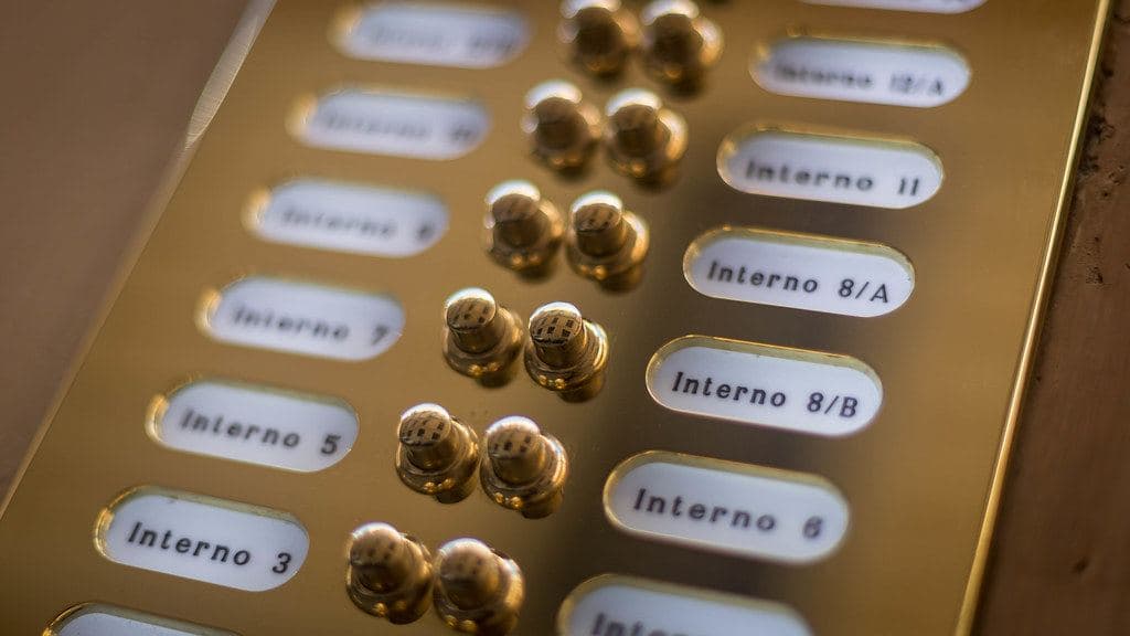 La pulsantiera in ottone di un citofono con i numeri degli interni