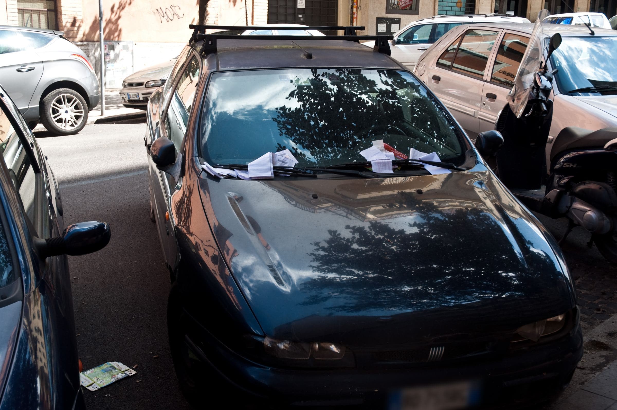 Multe infilate sotto il tergicristallo di un'auto parcheggiata